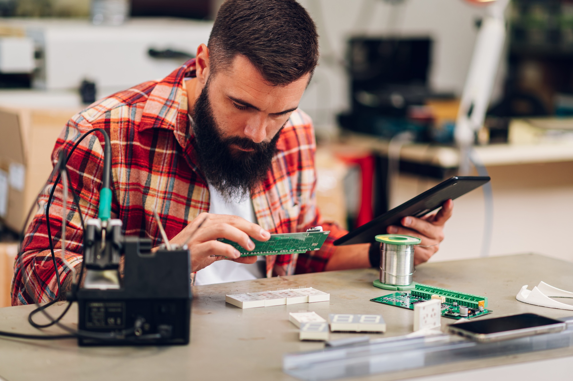 Electronics engineer working in a workshop with tablet