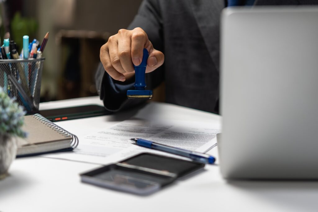 Man approving documents finance, banking, investments, marketing on desk. contract law, or rubber st